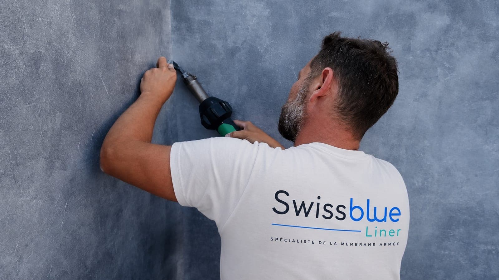 Technicien Swissblue Liner soudant à chaud une membrane armée dans un angle de bassin